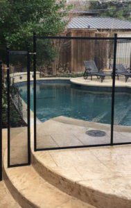 Black pool fence blocking off a patio in the Park Cities