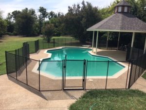 Custom black mesh pool gate designed for a large pool area.