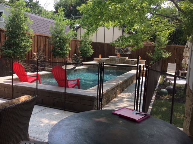 Bronze pool fence has a flexible swing piece to keep the dogs out of the garden.